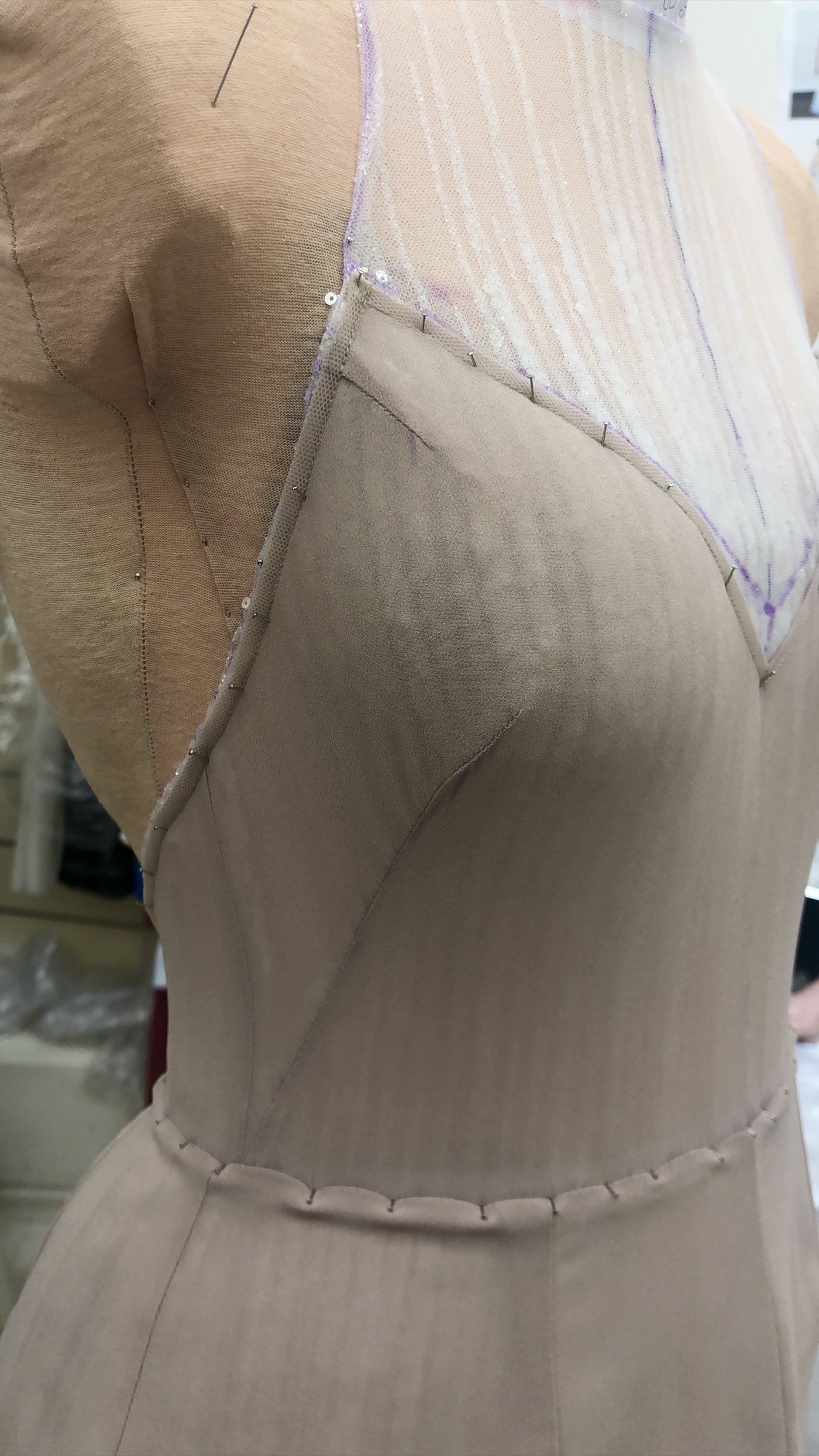 Close view of a custom bodice being constructed and fitted on a dress form