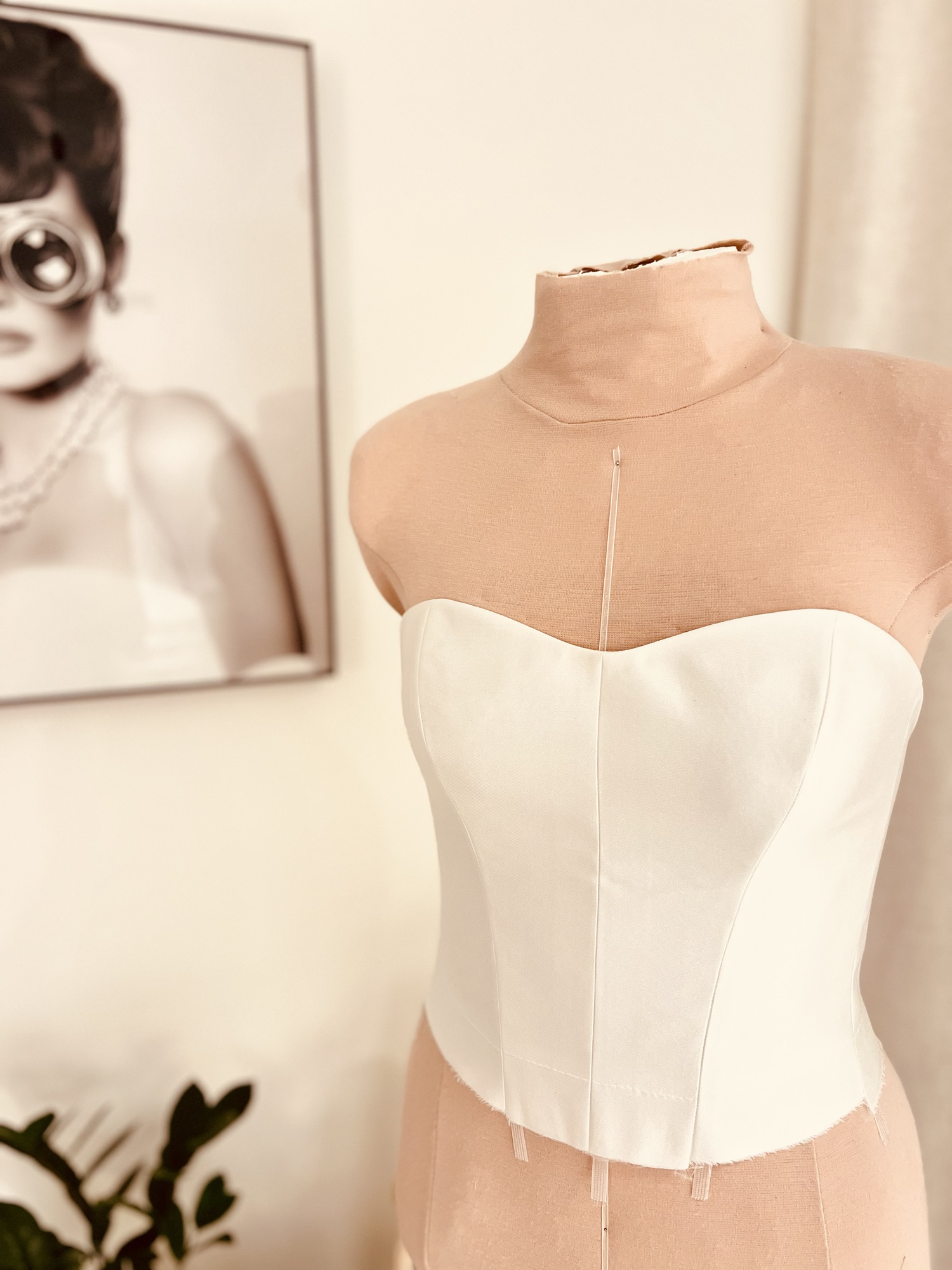 Ivory corset toile in progress on a dress form
