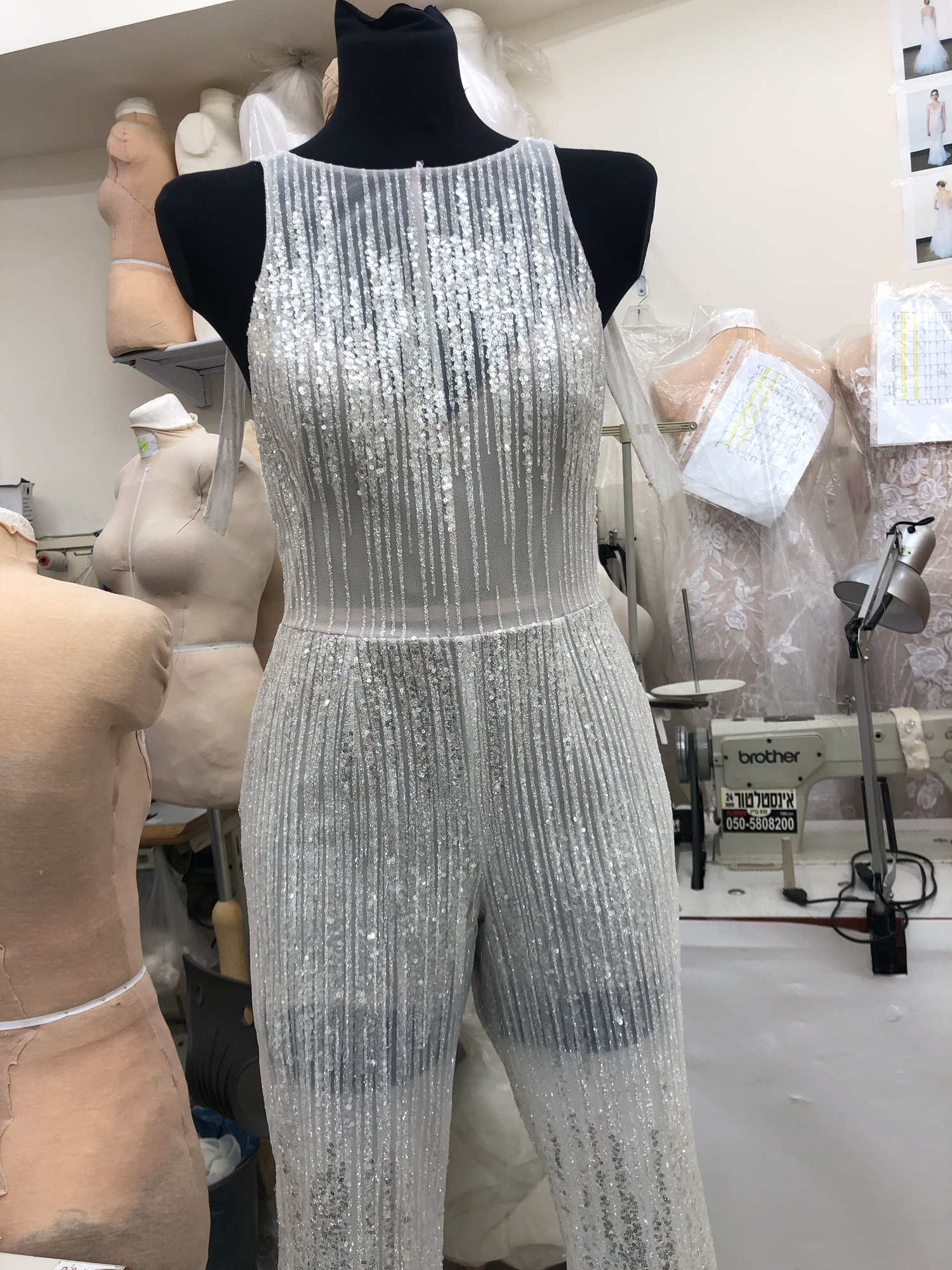 Silver hand-embellished couture jumpsuit on a dress form